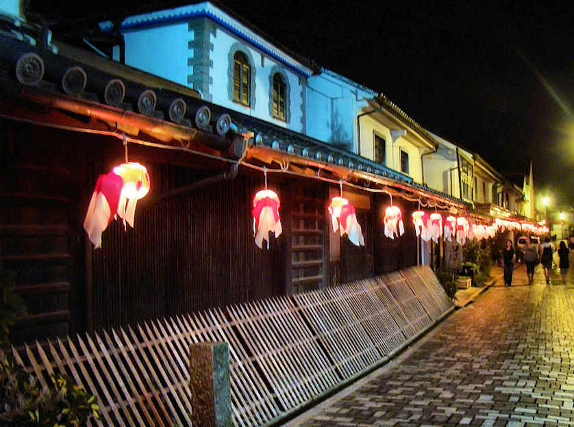 Calle en yanai, del matsuri que se realiza en agosto, donde se muestra un pasillo de una de sus calles donde hay lamparas en forma de peces globo colgados.